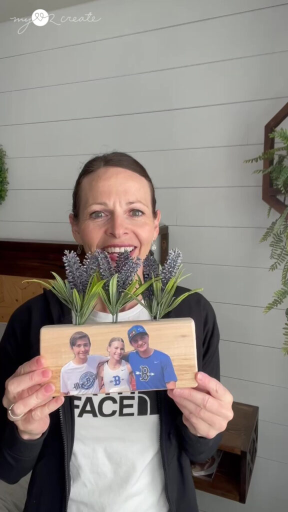 Woman showing his project mod podge image with flowers added to it